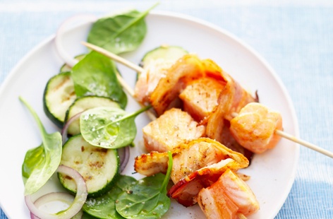 These grilled bacon and salmon skewers make a quick and simple meal for one. Served alongside stir-fried onion and courgette with young spinach leaves, this low-carbohydrate dish is ready in under half an hour.