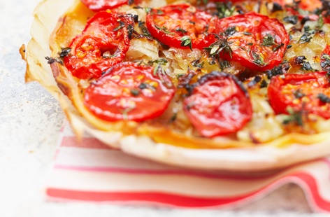 Who doesn't love a savoury tart? For this spin on a pissaladière, caramelised onions, garlic, cherry tomatoes, and thyme are baked on ready-made puff pastry.