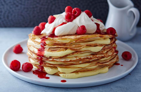Celebrate Pancake Day with this gorgeous centrepiece – velvety vanilla custard sandwich in between thin layers of pancakes, topped with fresh whipped cream and a sweet raspberry sauce.