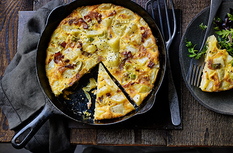 This quick frittata recipe is perfect when there's not much in the fridge. Crispy bacon, sweet leeks and tender potatoes are cooked with eggs and a generous amount of cheese for an easy dinner idea or weekend lunch - pack the leftovers into lunchboxes.