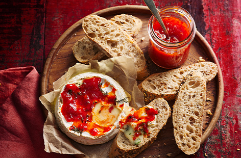 Now here's a recipe worth staying in for! Indulgent, gooey baked camembert gets an upgrade with a chilli relish to cut through the richness