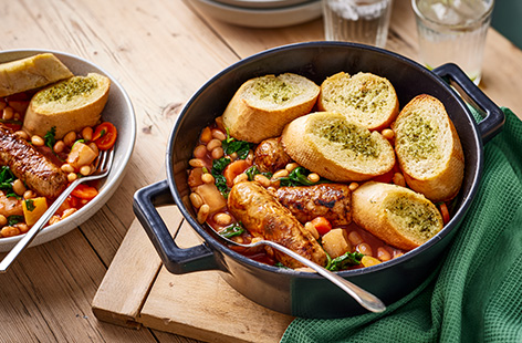 Take sausages and beans to the next level and top this wholesome family-friendly one pot recipe with crispy garlic bread