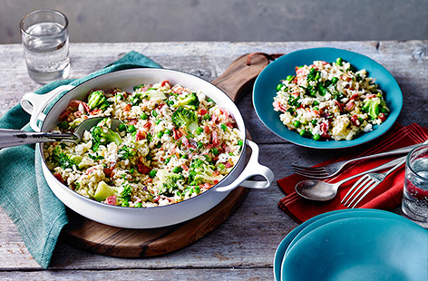 Vibrant green vegetables join the smoky flavours of bacon in this creamy weeknight risotto. Packed with broccoli and peas, a crumble of Greek-style salad cheese finishes the dish. 