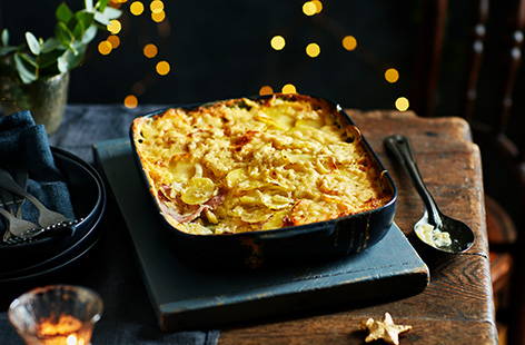Put your Christmas leftovers to good use with this warming cheesy potato and gammon bake recipe. Thinly sliced gammon joins potatoes and Cheddar blanketed under a nutmeg-infused cream sauce.