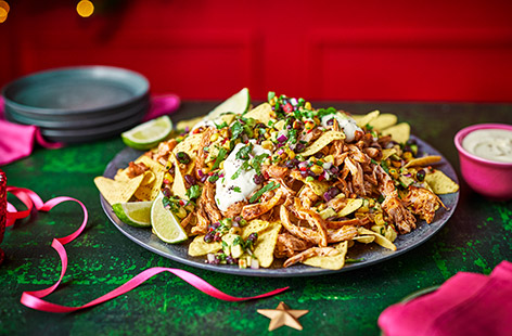 In this sharing dish, crunchy tortilla chips are topped with spicy shredded chicken and a charred corn salsa
