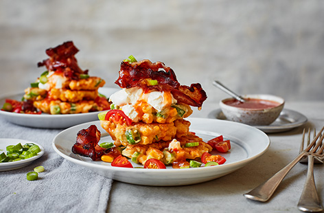 Turn brunch into dinner with this sweetcorn fritters recipe. Top a stack of fluffy sweetcorn fritters with crispy bacon, a dollop of créme fraîche, a scattering of spring onions and a drizzle of fiery sriracha sauce for a meal that works at any time of day