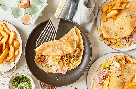 Not just for Pancake Day! Make this easy pancake recipe for lunch or an easy dinner at any time of year – lacy homemade crépes filled with caramelised onion, melting cheese and ham and served with chips for a wallet-friendly meal.