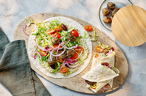 Use leftover lamb and spinach meatballs to whip up these easy Greek salad wraps with crunchy lettuce, sweet tomatoes and a dollop of creamy hummus. Perfect for a light summer dinner or even a packed lunch.