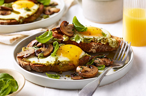 Take your eggs to the next level with a dollop of pesto! These crispy fried eggs pair perfectly with garlic mushrooms and toasted sourdough - a great weekend brunch idea.