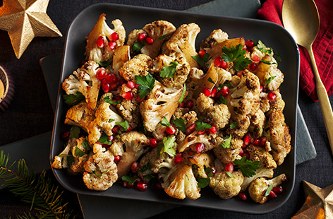 In search of a dairy and gluten-free side dish this Christmas? Try roasting cauliflower. Here it's gently spiced with cumin and topped with honey, fresh parsley and gems of pomegranate