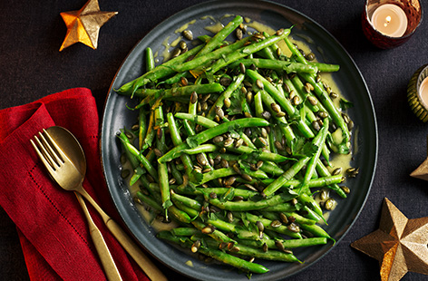 Transform green beans with this vegan and gluten-free side dish this Christmas. Beans are topped with toasted pumpkin seeds and coated in a sticky maple and mustard glaze. You won't be able to get enough of this.