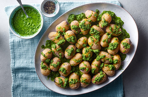 Give everyday ingredients the wow-factor. Baby potatoes are given a salty coating, then topped with a herby green sauce. These are a great side dish for your Easter lunch.