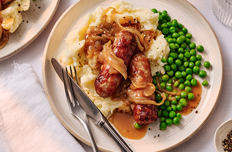 Bangers and mash is classic British food at its best! Hearty sausages are piled on top of smooth, buttery mashed potato, with a glossy roasted onion gravy to bring it all together. This sausages and mash recipe shows just how easy it is to make a seriously comforting meal.