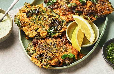 Here's a great dish to use up leftover spring greens that's tasty and affordable. These veggie fritters make a lovely lunch or quick dinner and the tahini yogurt sauce is a delicious accompaniment.