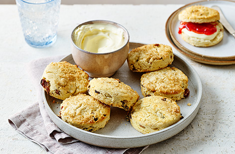 These gluten-free fruit scones are studded with sweet sultanas. Topped with a sprinkle of demerara sugar and serve with a generous spoonful of jam and clotted cream
