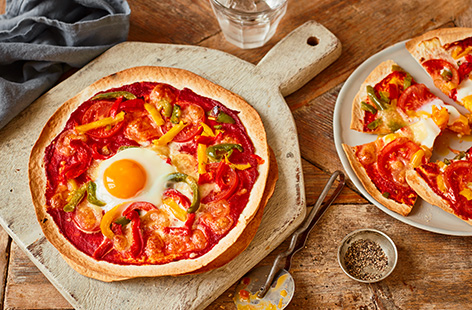 Have homemade pizzas in just 15 minutes with this easy tortilla pizzas recipe. Stack tortilla wraps for a super crunchy cheat's pizza base, then top with your favourite toppings - we've used peppers, tomatoes, melting mozzarella and cracked an egg on top!