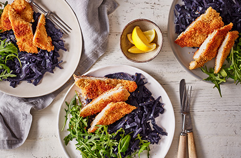 For dinner ready in 30 mins, try this couscous chicken schnitzel. Using couscous for an easy crispy coating, serve with braised red cabbage and rocket for a quick and healthy midweek dinner.