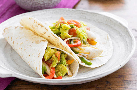 These easy chicken fajitas are bound to become a family favourite in no time. Cayenne-spiced chicken is mixed with colourful, crunchy peppers and a tomato-based guacamole before being encased in soft tortillas – delicious!