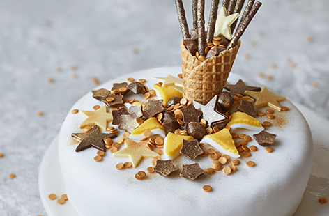 Kick off the festivities in style with this sparkly confetti cake that's quite literally exploding with chocolate stars and glittery gold sprinkles