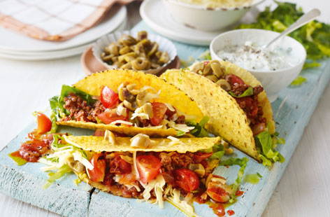 A fun friday night taco feast with spicy lamb mince and all the trimmings! The lamb is cooks in firery harissa paste with grated parsnip and chopped tomatoes, allowing plenty of time to prepare the rest of the fillings: sliced tomatoes, grated cheese, little gem and a refreshing cucumber dip.