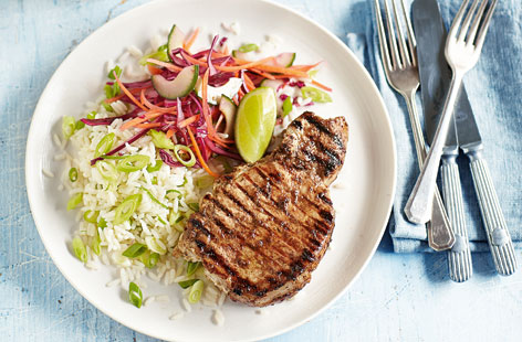 Jazz up pork chops with this delicious speedy supper idea. Use jerk paste to marinate the chops, then make the slaw. Adding lime zest and juice to the rice gives this Caribbean-influenced dish some extra zest.