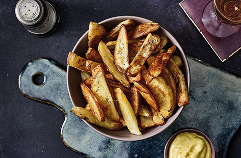 Liven up steak or a burger with these tasty skin-on oven-baked chips served with garlic and turmeric mayonnaise.
