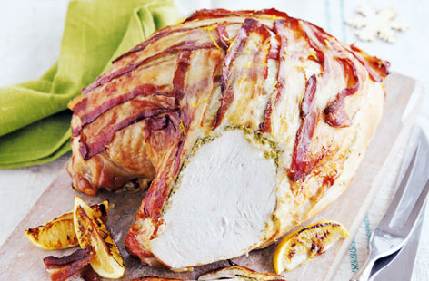 The turkey crown is a thrifty cut of meat that produces very little waste. A few generous tablespoons of pesto under the skin and a coat of pancetta draped over top of the crown bring a taste of Italy to the table in this impressive roast recipe.