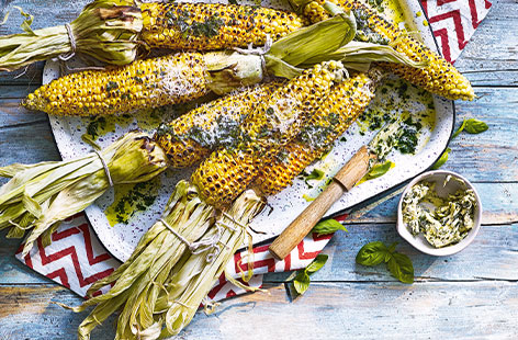 This is the ultimate corn on the cob recipe to make at barbecues all summer long. The smoky charred corn is brushed with a simple basil and Parmesan butter – the melting cheese and herby butter take this vegetarian barbecue classic to the next level.