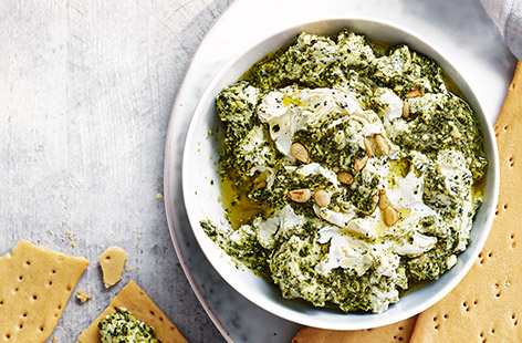 Whip up this moreish dip and enjoy in the sunshine with friends – perfect for a mid-afternoon snack or simple starter to share. Creamy feta is swirled with vibrant herby pesto and topped with crunchy pine nuts for a delicious snack ready in just 10 minutes
