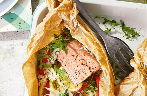 Cooking fish inside a baking-paper parcel seals in all the flavour – and saves on the washing up! Try this simple salmon recipe with fennel, sweet red peppers and lemon for a quick dinner idea this summer.