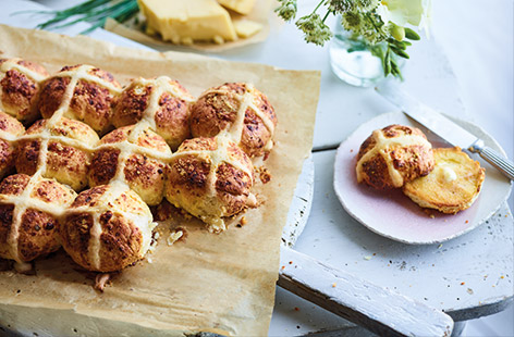 Hot cross buns, but not as you know them! We’ve swapped out the sweet dried fruit for a triple cheese hit in this savoury hot cross bun recipe. Cheddar, Parmesan, pockets of feta and fresh chives are baked into the fluffy buns for a deliciously cheesy East