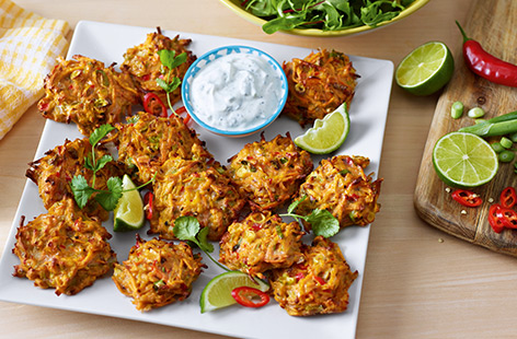Perfect for sharing, these baked sweet potato fritters are full of veg and flavoursome spices that make them a delicious snack with cooling tzatziki for dipping