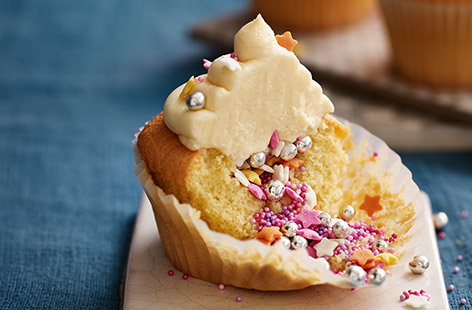 These buttery vanilla cupcakes look simple from the outside, but hide a fun and colourful filling, piñata-style. Creamy white chocolate buttercream covers bright sprinkles inside - perfect for making with the kids or serving at a birthday party.