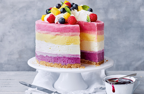 This showstopping rainbow frozen yogurt cake is perfect for summer birthdays or a seriously impressive way to end a barbecue. Colourful layers of blueberry, lime, mango and raspberry frozen yogurt sit on a crunchy biscuit base for a towering fruity dessert