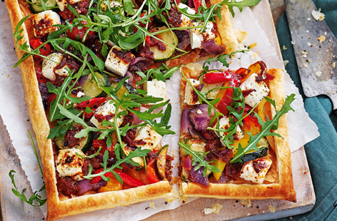 Topped with a drizzle of harissa, roasted vegetables, creamy feta chunks and fresh rocket, this crisp puff pastry tart makes a colourful vegetarian-friendly Sunday lunch. To give your tart a twist, replace the feta with vegetarian blue cheese or mozzarella