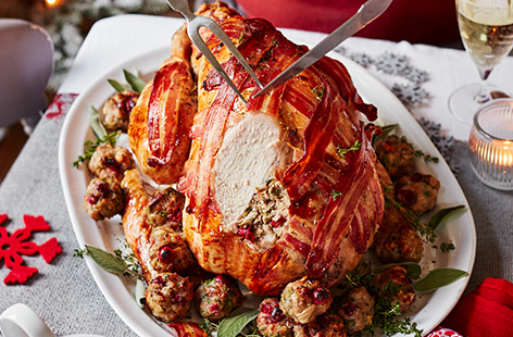 A festive walnut and cranberry stuffing, sweet maple butter and a bacon lattice topping makes this Christmas Day classic roast turkey recipe the perfect centrepiece for your celebrations.