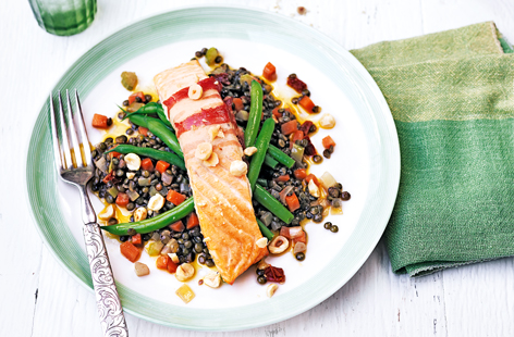 If you're planning a cosy night in, then serving up this super-easy dish of tender salmon wrapped in smokey pancetta, on a bed of sundried tomatoes and lentils, will not disappoint. 